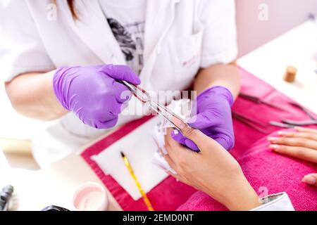 Artificial nail enhancements manicure process, having perfect nails for the date Stock Photo