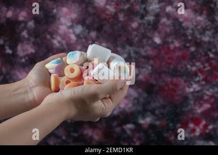 Holding marshmallow and jelly beans mix in the hand Stock Photo