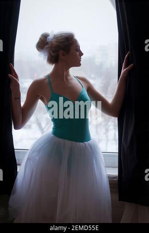 Young, graceful ballerina in pointe shoes and black dress in the studio. Choreography and dancing classes concept. Creative ideas of ballet posing Stock Photo