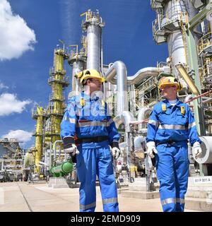 group of industrial workers in a refinery - oil processing equipment and machinery Stock Photo