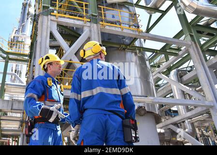 group of industrial workers in a refinery - oil processing equipment and machinery Stock Photo
