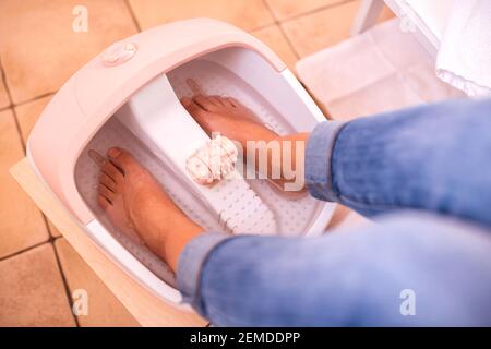 Foot spa pedicure, feet soaked in foot bath tub, healthy feet concept Stock Photo