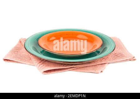 Two empty plates on pink cotton towel isolated on white background. Stock Photo