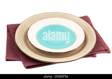 Two empty plates on purple cotton towel isolated on white background. Stock Photo
