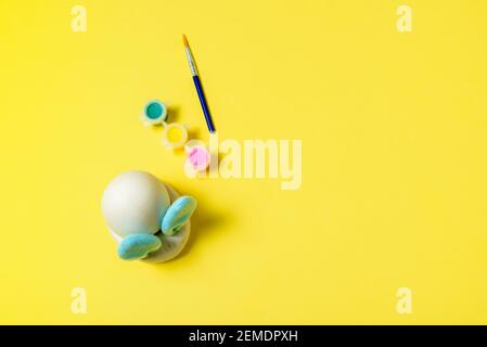 Easter egg painting set with bunny. Brush and paints on yellow background Stock Photo