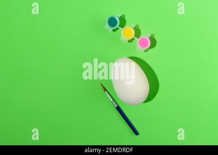 Easter egg painting set. Brush and paint on green background Stock Photo