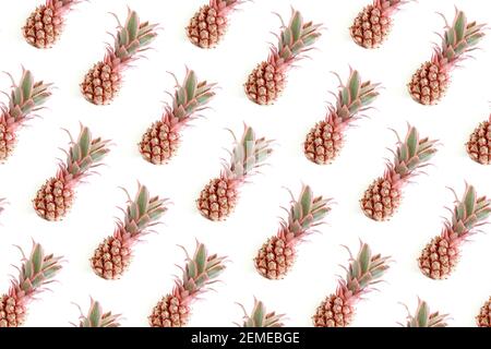 Trendy repetitive pattern made of pink pineapples. Summertime concept on a white background. Stock Photo