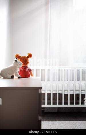 Children's room with an empty cradle and toys on the dresser. Copy