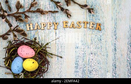 Happy Easter. Easter eggs in the nest. Willow twigs. Holy Easter. Blue turquoise background. Stock Photo