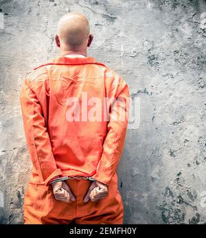 Handcuffed prisoner waiting at prison wall for death penalty Stock Photo
