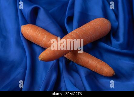 Two fresh carrots on blue background Stock Photo