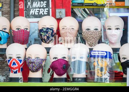 London, UK - 5 February, 2021 - Cloth face masks with various patterns displayed on mannequin heads for sale on Wood Green high street Stock Photo