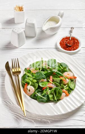 Salad of microgreens with avocado shrimps, baby spinach leaves, fresh sunflower sprouts, yogurt and tahini dressing with chili flakes served on a whit Stock Photo