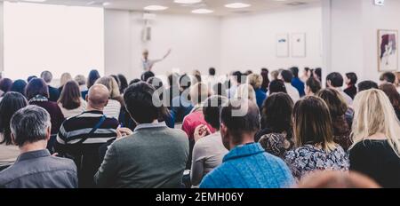 Woman giving interactive motivational speech at entrepreneurship workshop. Stock Photo