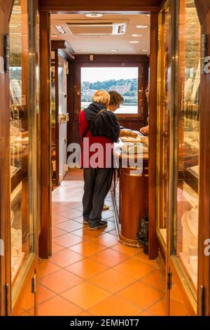 Inside an Italian jewelry shop on the bridge Ponte Vecchio in Florence. The shop has terracotta floors, glass cabinets, a safe and air conditioner. Stock Photo