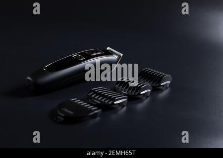 Shaving machine for barber with attachments on black background. Stock Photo