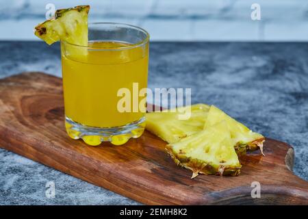 Slices of pineapple and pineapple juice on wooden board Stock Photo