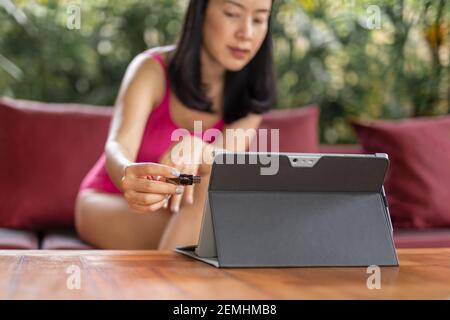 Woman in swimming suit hand plugging a flash drive on a laptop. Stock Photo
