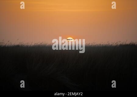 Drone quadcopter with digital camera in flight at sunset, Silhouette of drone at sunset Stock Photo