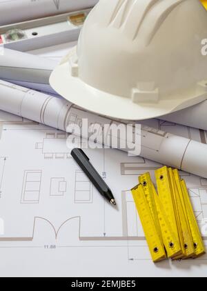 Project blueprints and engineer hardhat white color on drawings background. Housing project construction, architect site office concept. Stock Photo