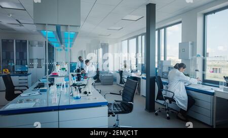 Modern Medical Research Laboratory: Team of Scientists Working with Pipette, Analysing Microbiological Sample, Talking. Advanced Scientific Lab for Stock Photo