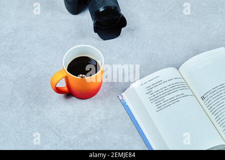 Open book, camera and coffee cup on gray table Stock Photo
