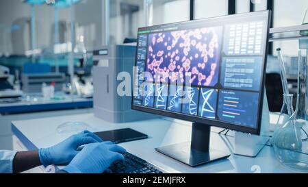 Modern Medical Research Laboratory: Portrait of Male Scientist working on Computer Showing DNA concept. Scientific Lab and Medicine Development Stock Photo