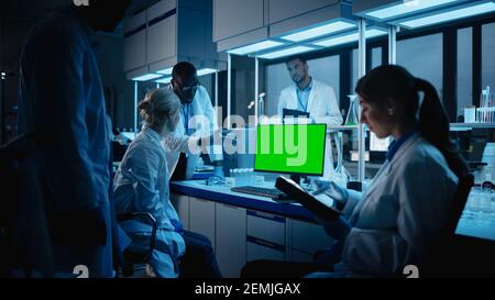 Medical Research Laboratory Meeting: Diverse Team of Scientists Use Personal Computer Showing Green Chroma Key Screen. Advanced Lab for Medicine Stock Photo