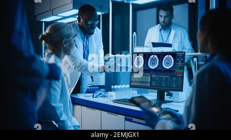 Medical Research Laboratory Meeting: Diverse Team of Scientists Use Computer Showing MRI Brain Scans, Discuss Innovations. Advanced Scientific Lab for Stock Photo