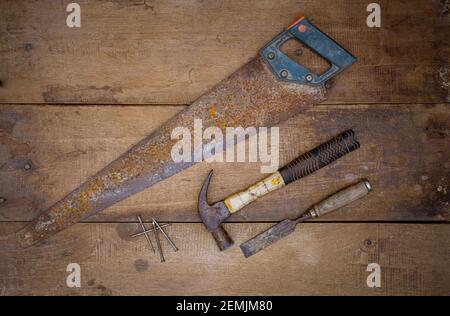 Hammer saw and chisel Collection of woodworking old handtools on a rough workbench wooden Stock Photo