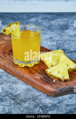 Slices of pineapple and pineapple juice on wooden board Stock Photo