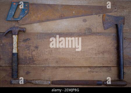 Hammer saw and chisel collection of woodworking old handtools on a rough workbench wooden Stock Photo