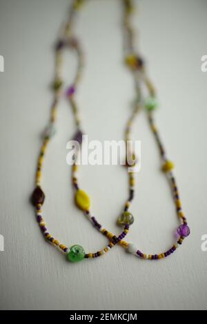 beads of beads and different stones on a white texture table. Stock Photo