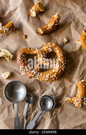 Hard Twisted Pretzel with Salt Against Brown Paper Background Stock Photo