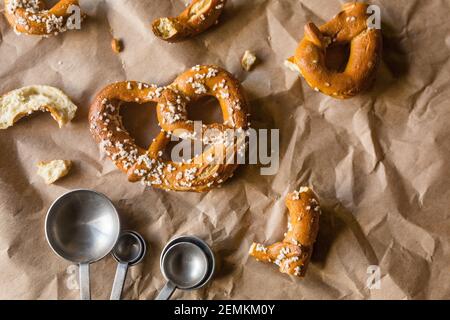 Hard Twisted Pretzel with Salt Against Brown Paper Background Stock Photo
