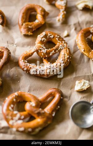 Hard Twisted Pretzel with Salt Against Brown Paper Background Stock Photo