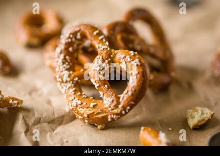 Hard Twisted Pretzel with Salt Against Brown Paper Background Stock Photo