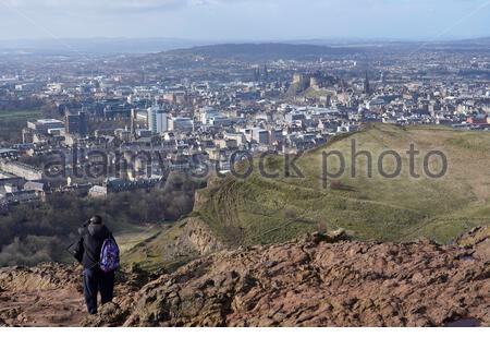 Edinburgh, Scotland, UK. 25th Feb 2021. People enjoying the sun and outdoors in Holyrood Park. From the summit of Arthurs seat with a view of Edinburgh Castle.  Credit: Craig Brown/Alamy Live News Stock Photo