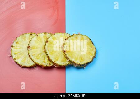 Slices of pineapple on pink and blue background Stock Photo