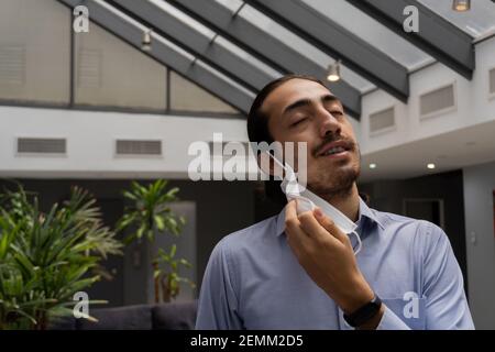 man happily removing medical protective face mask. feeling of liberation, freedom. life style. man in office. no more coronavirus, covid. Stock Photo