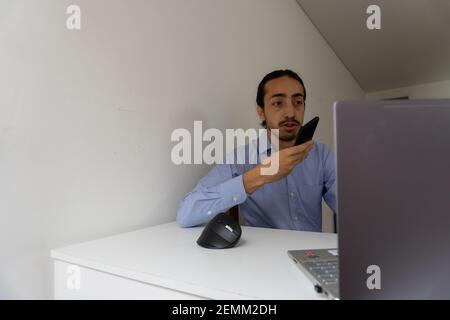 businessman sending voice note. man using voice recognition on his smartphone. home office Stock Photo