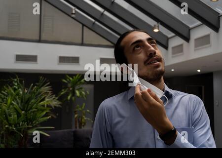 man looking forward to the future without coronavirus. removing medical face mask. man in office. man feeling liberated, freedom mood. man looking up Stock Photo