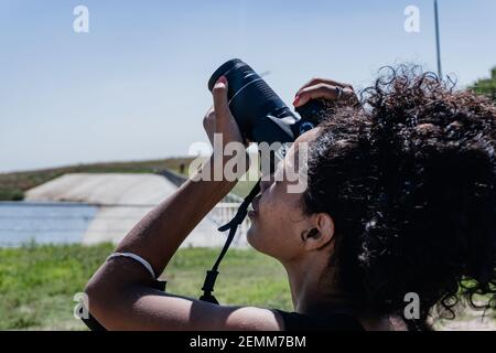 afro american woman with a professional camera taking pictures of the sky at the north waterfront. vicente lopez. buenos aires. Stock Photo