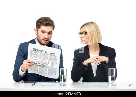 young anchorman reading sport news near blonde colleague isolated on white Stock Photo