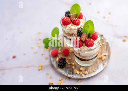 Greek yogurt raspberry parfaits in glass jars, small healthy dessert Stock Photo