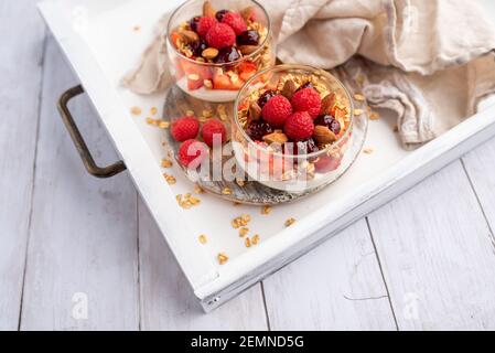 Greek yogurt raspberry parfaits in glass jars, small healthy dessert Stock Photo