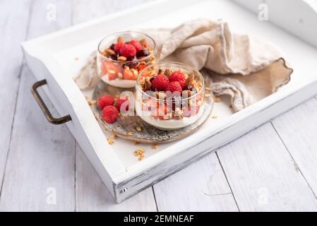 Greek yogurt raspberry parfaits in glass jars, small healthy dessert Stock Photo