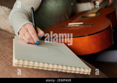 Close-up of a middle-aged woman writing in a notebook. Music learning Stock Photo