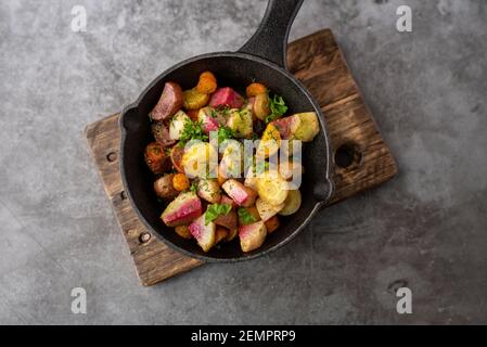 Roasted vegetables mix in a cast iron mini skillet ready to serve Stock Photo