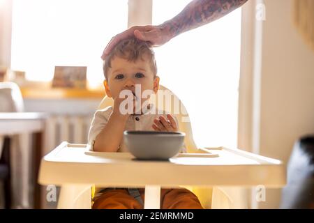 Father’s hand stroking child's head Stock Photo